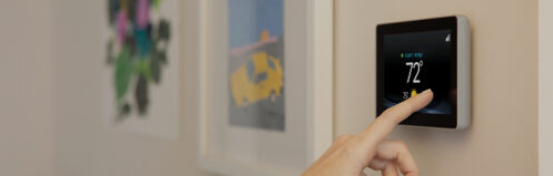 Woman's hand adjusting the temperature on a smart thermostat