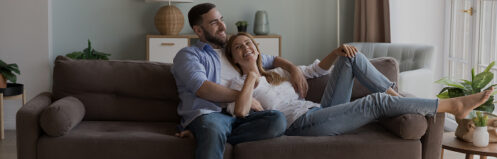 Happy couple sitting on a couch in their Central Wisconsin home