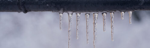 Frozen pipe with icicles hanging down in Central WI